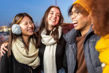 Kışın dışarıda dikilerek eğlenen çok ırklı bir grup genç. Arkadaşlık ve gençlik toplumu kavramı