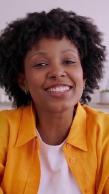 Dikey video. Arkadaşlarıyla konuşan neşeli genç bir kadının görüntüsü, evden video konferansı. Uzak çalışma yaşam tarzında iletişim yetenekleri gösteriyor. Seyahat ve iş konsepti