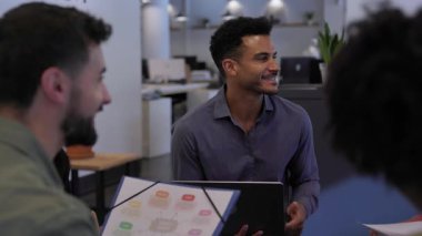 İş arkadaşları bir çemberde oturup ofiste gayri resmi bir toplantı yapıyorlar. Ekip üyeleri rahat bir iş yeri tartışmasında fikirlerini paylaşıyor ve işbirliği yapıyorlar. Takım çalışması ve işbirliği kavramı.