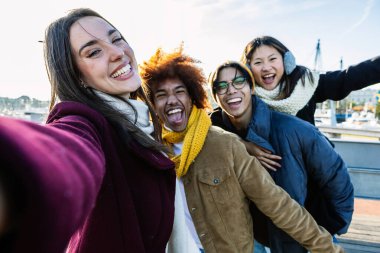 Çeşitli gençler kış mevsiminde dışarıda selfie çektirirken eğleniyorlar.