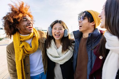 Çeşitli gruplar mutlu arkadaşlar kış tatilinde birlikte eğleniyorlar. Açık havada gülen çok kültürlü gençler. Arkadaşlık kavramı