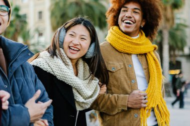 Bir kış günü bir grup neşeli çoklu etnik arkadaş birlikte yürüyor, birlikte eğleniyor ve gülüyorlar.
