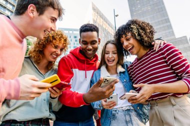 Çok ırklı bir grup genç, şehir caddesinde cep telefonu kullanarak eğleniyor. Milenyum insanları cep telefonu uygulamasından sosyal medya içeriğini izlerken gülüyorlar. Teknoloji ve gençlik kavramı
