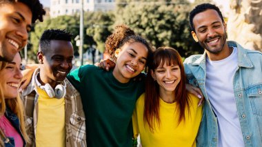 Mutlu çeşitli bin yıllık öğrenciler ve en iyi arkadaşlar güneşli bir günde şehir sokaklarında gülüp kaynaşarak dışarıda vakit geçiriyorlar. Gençlik, dostluk ve pozitif yaşam tarzı konsepti.