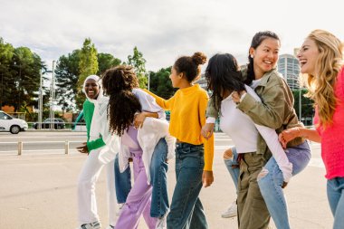 Bir grup gülen kadın dışarıda eğleniyor. Çeşitli arkadaşlar rahatlamış bir ortamda neşe ve kahkaha paylaşıyorlar. Arkadaşlık ve pozitiflik kavramı.