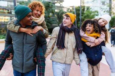 Genç çok ırklı arkadaşlar kış tatilinde şehir sokağında eğleniyorlar. Seyahat, gençlik toplumu yaşam tarzı ve arkadaşlık kavramı
