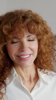 Ofiste duran orta yaşlı bir iş kadınının dikey portresi. Modern bir çalışma alanında kendine güvenen profesyonel bir yönetici. İş ve liderlik kavramı.