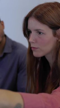 Terapi grubu oturumunda genç bir kadının takım arkadaşını desteklediği dikey HD video. Bir destek grubunun üyeleri empati ve cesaretlendirmeyi güvenli bir alanda paylaşıyorlar. Akıl sağlığı ve refah kavramı.