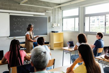 Genç öğrenci grubu sınıfta fen dersi öğreniyor. Çeşitli insanlar lisede akademik bir derse katılıyorlar. Eğitim ve bilim konsepti.