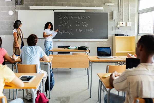 Sınıfta akademik ders sunan genç bir kız öğrenci. Farklı insanlar birlikte bir lise öğrenme etkinliğine katılıyorlar. Eğitim ve sunum kavramı.