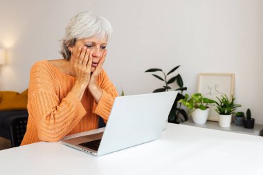 Endişeli profesyonel iş kadını dizüstü bilgisayardan kötü haberler okuyor.