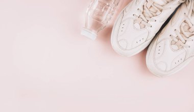 Sağlıklı bir yaşam tarzı. Pembe arka planda spor malzemeleri. Spor konsepti. Daire yalan söylüyordu. Kopyalama alanı olan üst görünüm. Pankart.