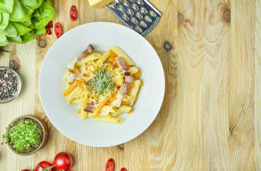 Peynirli İtalyan makarnası, balkabağı ve hafif ahşap arka planda kızarmış pastırma. İtalyan mutfağı. Boşluğu kopyala.