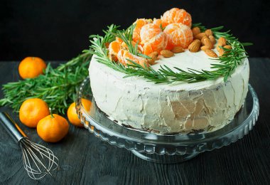 Mandalinalı, bademli ve biberiyeli doğum günü pastası. Karanlık bir arka planda Noel pastası. Boşluğu kopyala.