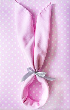 Pembe arka planda Paskalya tavşanı şeklinde bir peçete. Hafif Paskalya. Hafif arkaplan. Boşluğu kopyala.