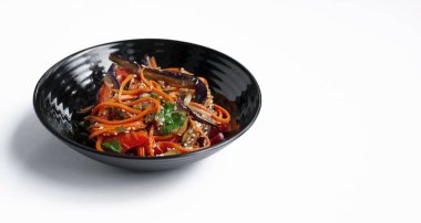 Hafif arka planda kızarmış patlıcanlı sebze salatası. Vejetaryen yemeği. Koyu bir kasede izole edilmiş marul. Yakın plan. Boşluğu kopyala.