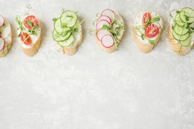 Hafif arka planda sebzeli ve otlu çeşitli vejetaryen sandviçler. Düzgün beslenme. Diyet yemek. Yemek arkaplanı. Üst Manzara. Boşluğu kopyala.