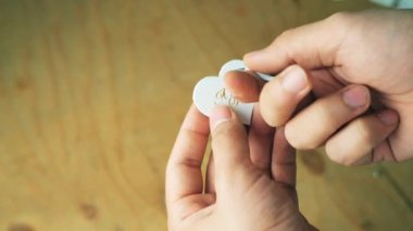 Tanner isim anahtarlığının parçalarını topluyor. El yapımı deri..