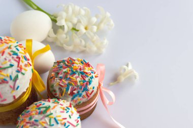 Geleneksel Paskalya pastaları ve beyaz arka planda Hyacinthus çiçekleri ve metin için kopya alanı. Geleneksel Kulich, Paska Paskalya Ekmeği. Kartpostal