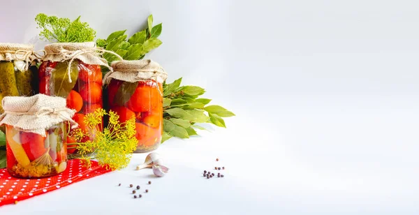 Pots en verre avec tomates marinées maison, scellés avec couvercle métallique sur fond blanc. concombres marinés, brins d'aneth et feuilles de laurier. Bannière isolée de style campagnard avec zone de texte. copyspace. — Photo