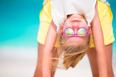 Küçük kız ve babası mükemmel kumsalda yaz tatili keyfini