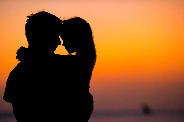 Silueta de niña y papá en la puesta de sol en la playa —  Fotos de Stock