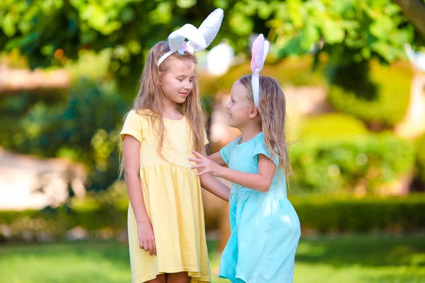 Two adorable little sisters wearing bunny ears on Easter day outdoors — Stock Photo, Image