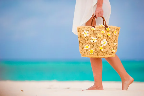 여성의 손에 하얀 해변에 선글라스와 frangipani 꽃 근접 촬영 아름 다운 가방 — 스톡 사진