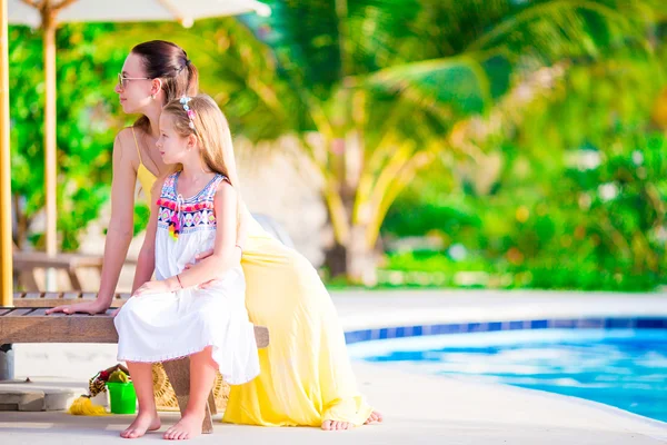 Giovane madre e figlia rilassante vicino alla piscina — Foto Stock