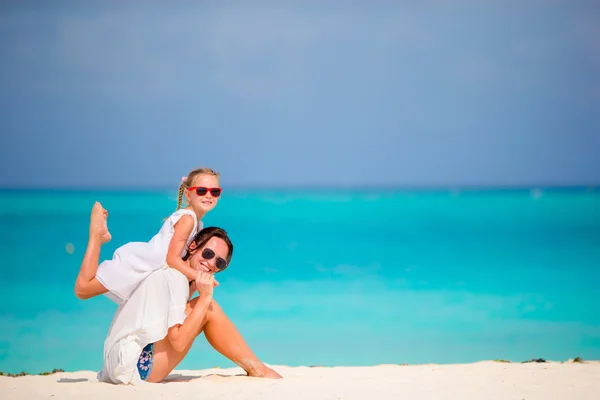 Niña y madre joven durante las vacaciones en la playa — Foto de Stock