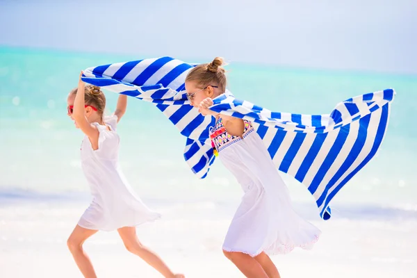 楽しい女の子白い砂とターコイズ ブルーの海の水と熱帯のビーチのタオルで実行 — ストック写真