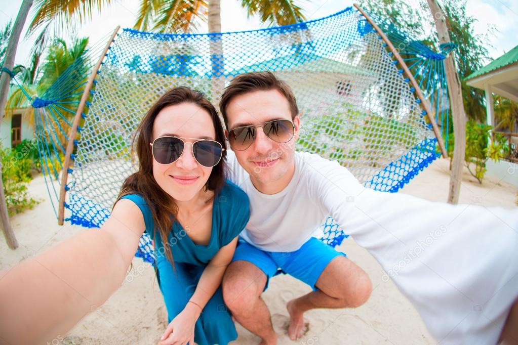 Happy couple making selfie relaxing in hammock