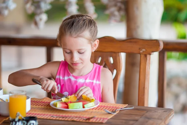 Rozkošná holčička se snídaní v venkovní kavárně — Stock fotografie