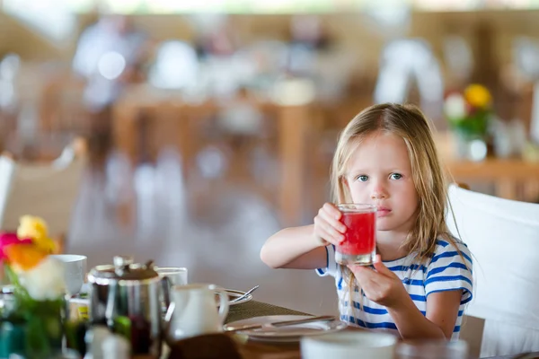 Liebenswertes kleines Mädchen frühstückt im Café im Freien — Stockfoto