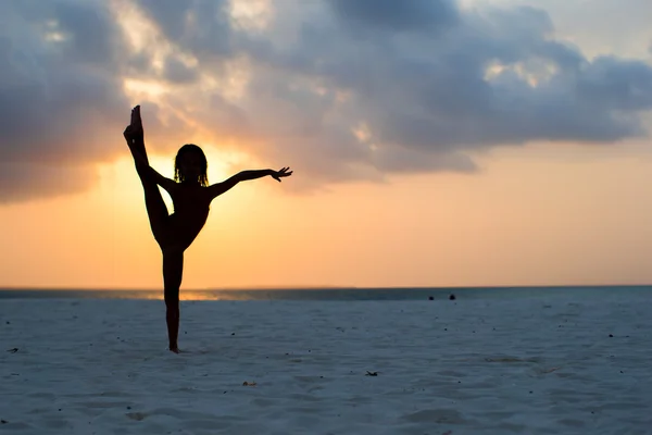 Silueta Rozkošná holčička na bílé pláži při západu slunce — Stock fotografie