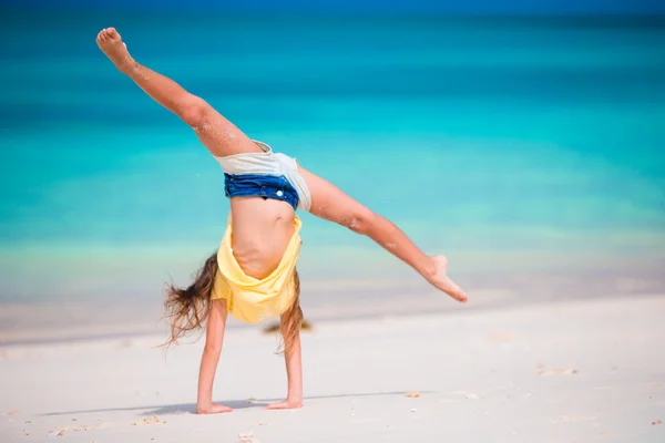 Schattig actief klein meisje aan het strand tijdens de zomervakantie — Stockfoto
