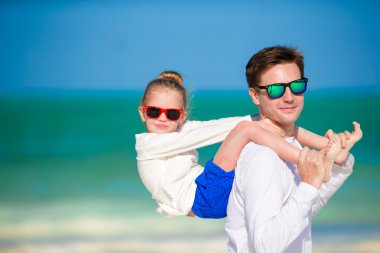 Küçük kız ve baba tropikal plajda eğlenmek