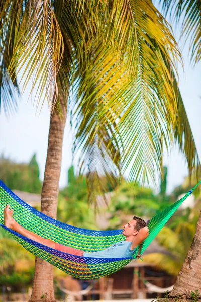 Young man in hammock at exotic tropical vacation — Stock Photo, Image