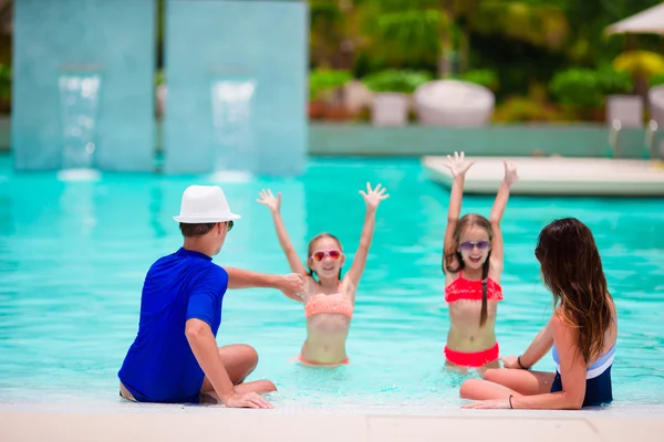 Famiglia felice con due bambini in piscina . — Foto Stock