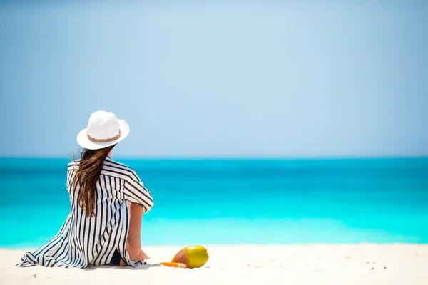 Mladá žena na bílé pláži s kokosem — Stock fotografie
