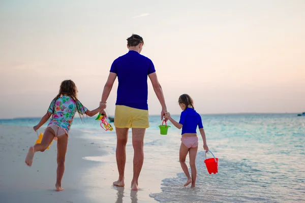 Glad familj i solnedgången på stranden — Stockfoto