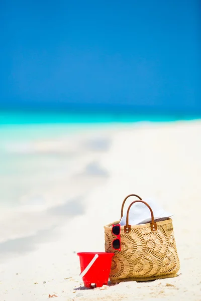 Accesorios de playa - bolsa de paja, sombrero blanco y gafas de sol rojas en la playa — Foto de Stock