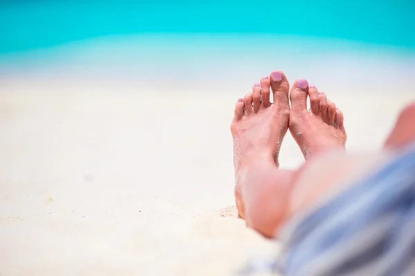 Young woman sunbathing on white beach. Legs. — Stock Photo, Image