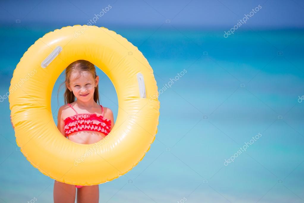 Adorable little girl with inflatable rubber circle during beach ...