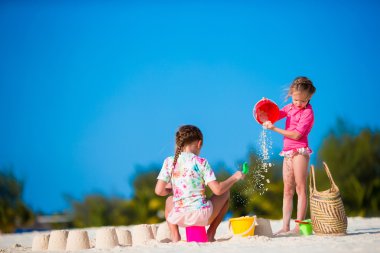 Küçük şirin kızlar ile oynarken oyuncaklar sırasında tatil tropikal plaj