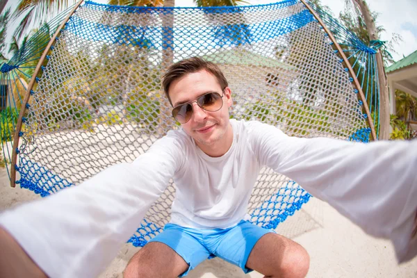 Giovane uomo fare selfie rilassante su amaca — Foto Stock