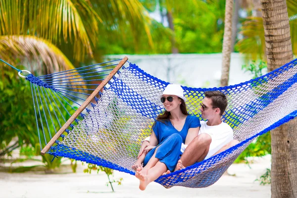 Happy couple on summer vacation relaxing in hammock — Stock Photo, Image