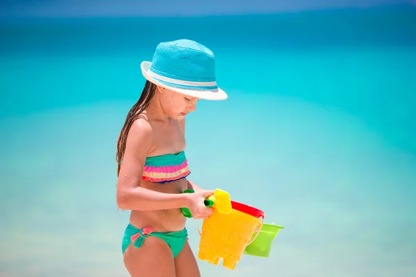 Little girl collecting seashells on white sand beach — Stock Photo, Image