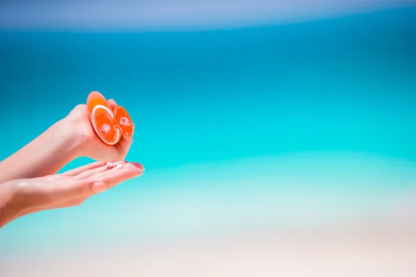 Closeup zonnebrandcrème fles achtergrond turquoise water — Stockfoto