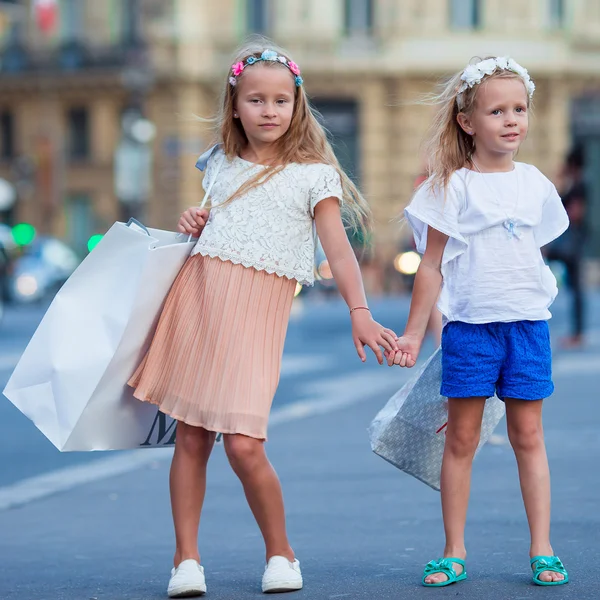 Entzückende Mode kleine Mädchen mit Paketen im Freien in der europäischen Stadt — Stockfoto